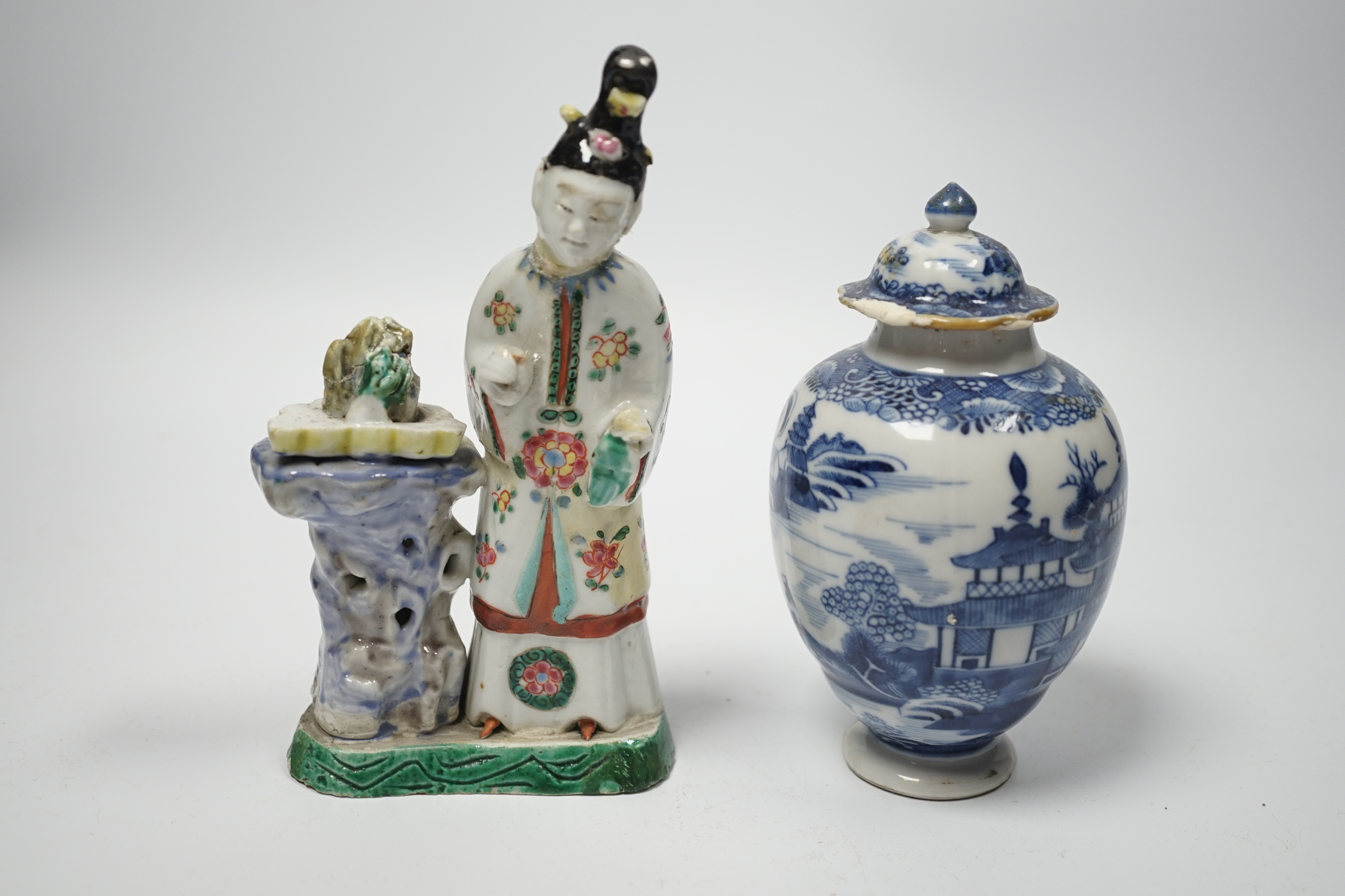 An 18th century Chinese enamelled porcelain figure of a Lady standing by rockwork, a similar miniature vase and a blue and white tea caddy and cover, largest 17cm high